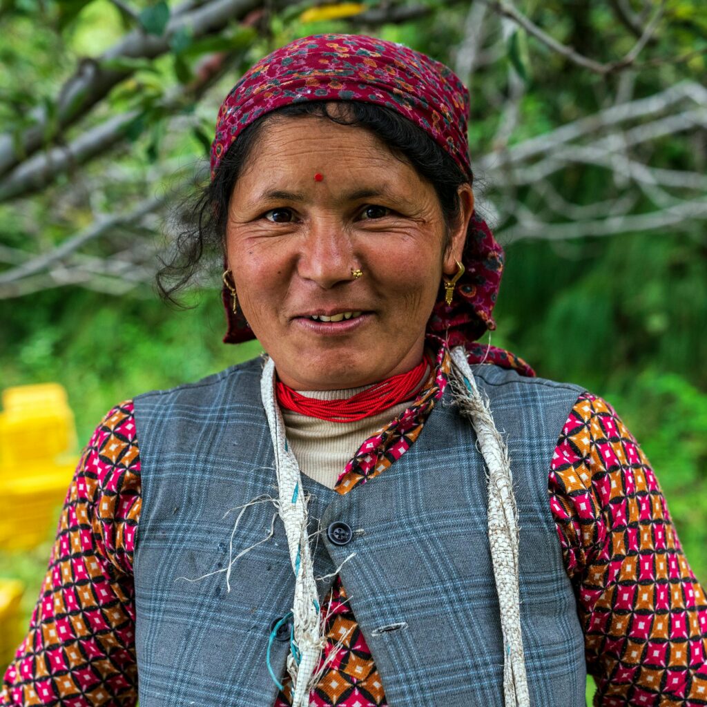 pexels-photo-4993172-4993172 Portrait of a smiling woman in colorful Indian clothing with a natural blurred background.